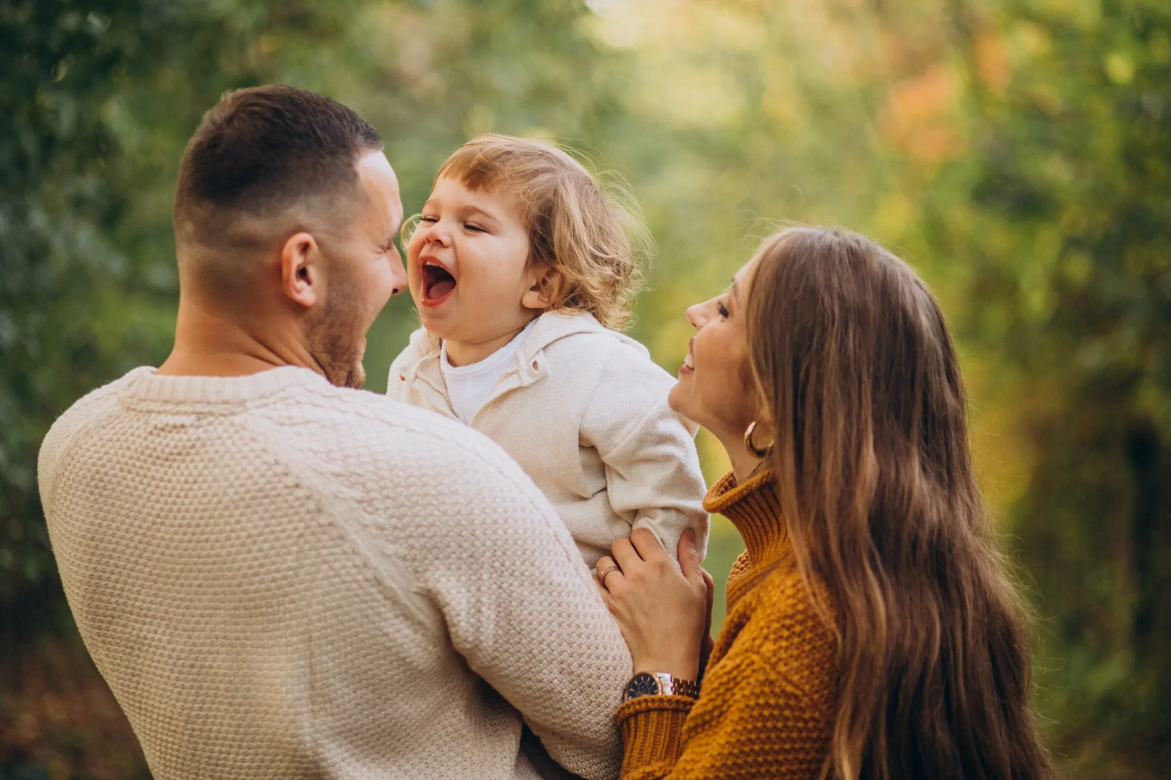 A young family walking together through an autumn park
